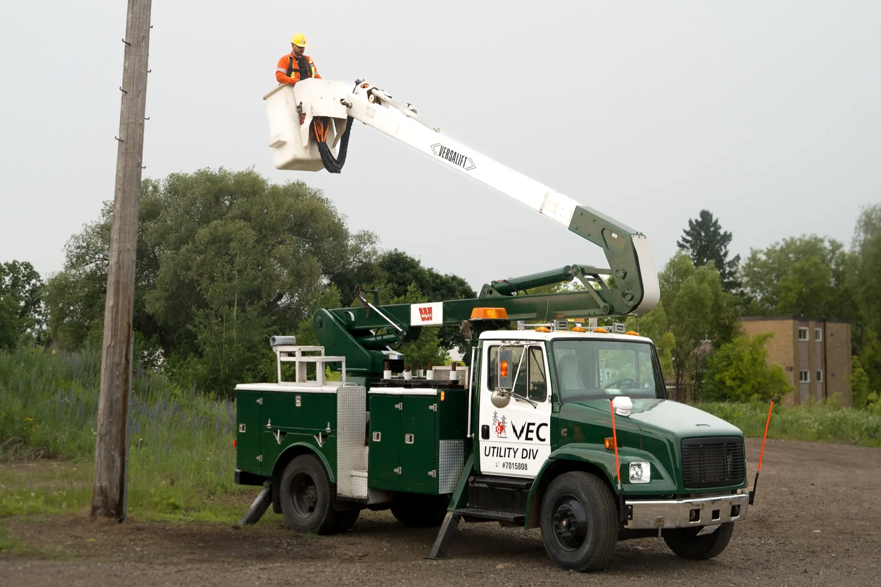 Veteran Electric utility truck with a crew member in the elevated bucket